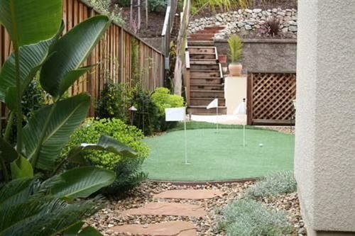 A close-up, top-down view of vibrant green artificial turf with a slightly textured, realistic appearance.