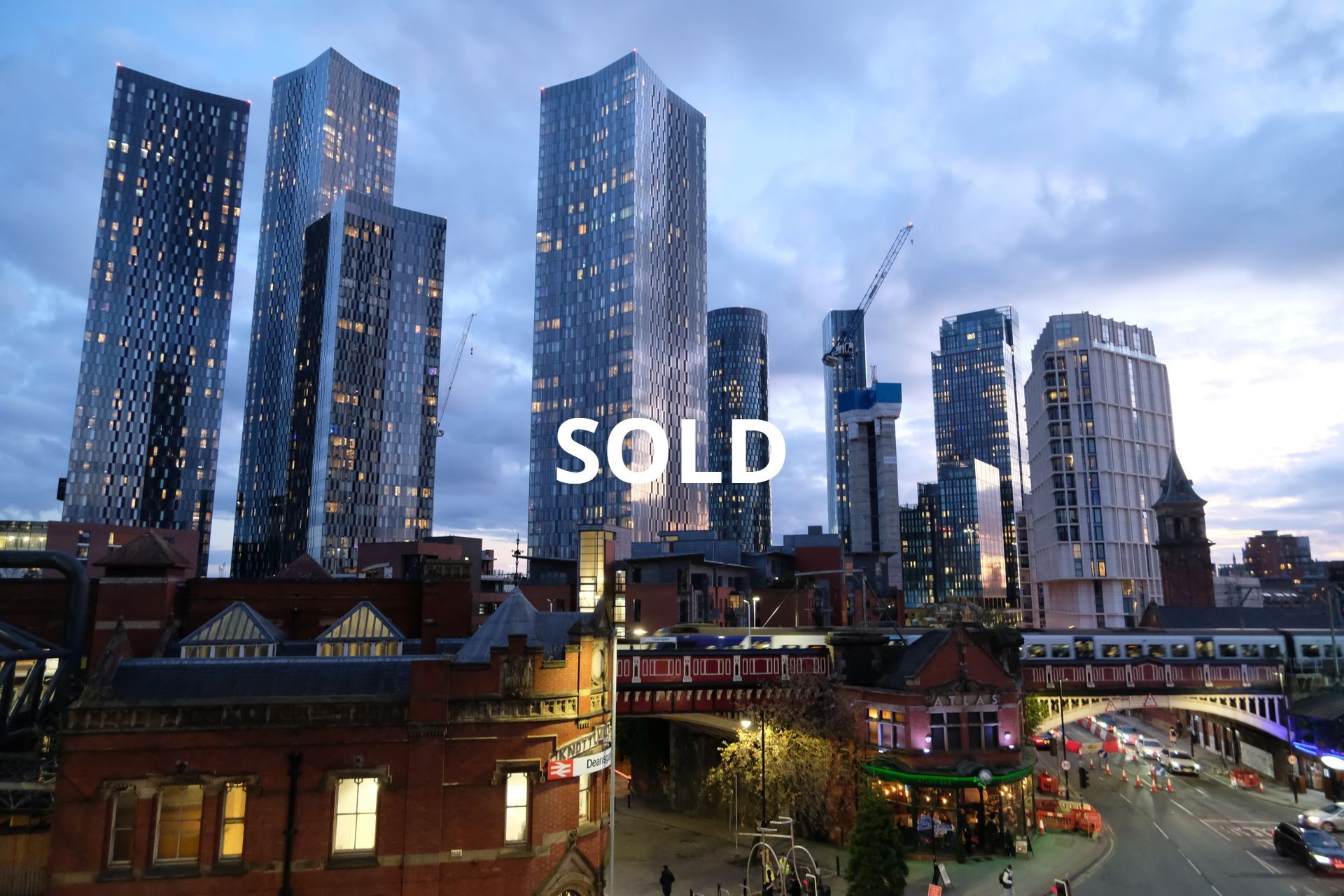 Cityscape with tall buildings, train tracks, and a 