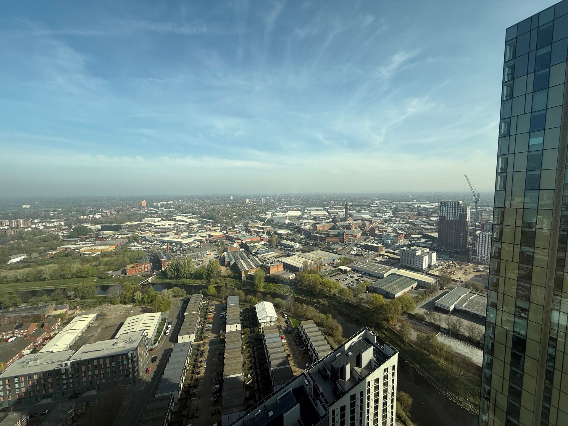 High-angle cityscape view on a clear, sunny day; modern skyscraper on right.