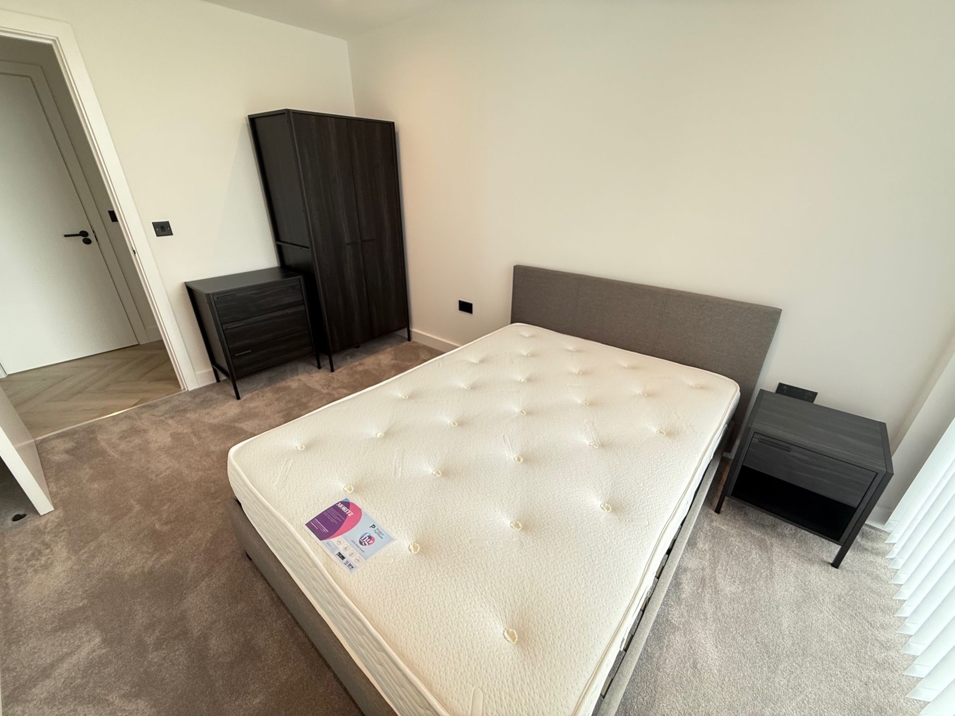 Bedroom with bed, nightstands, and dark wardrobe.