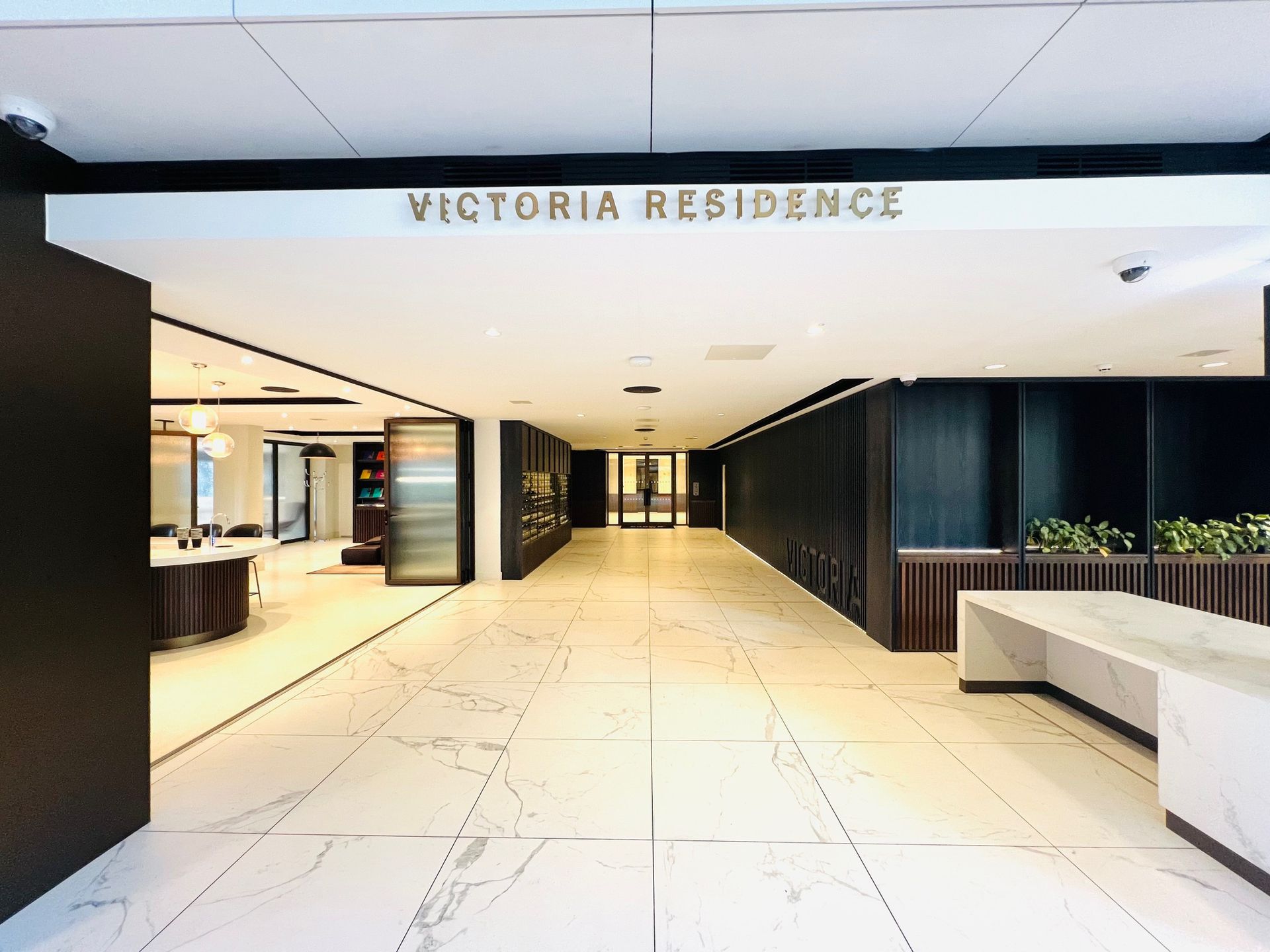 Lobby entrance with white marble floors, dark walls, and