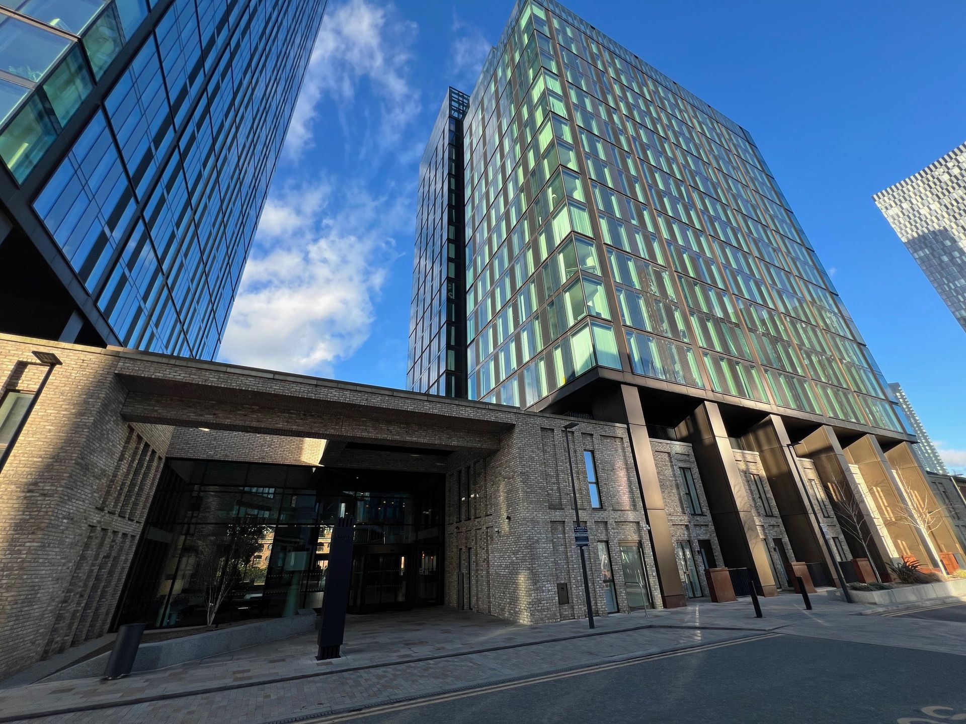 Modern high-rise office buildings with glass and brick facades under a blue sky.