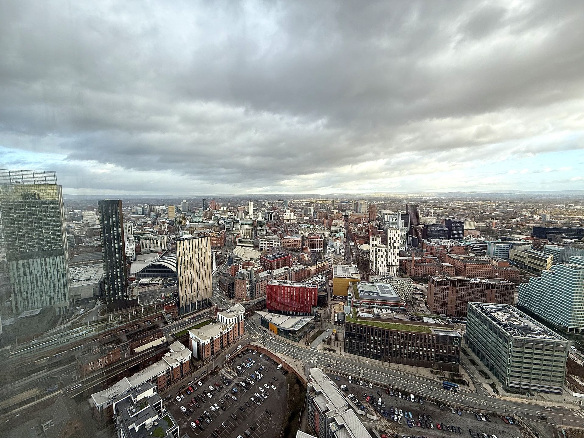 Cityscape under a cloudy sky, with skyscrapers and buildings.