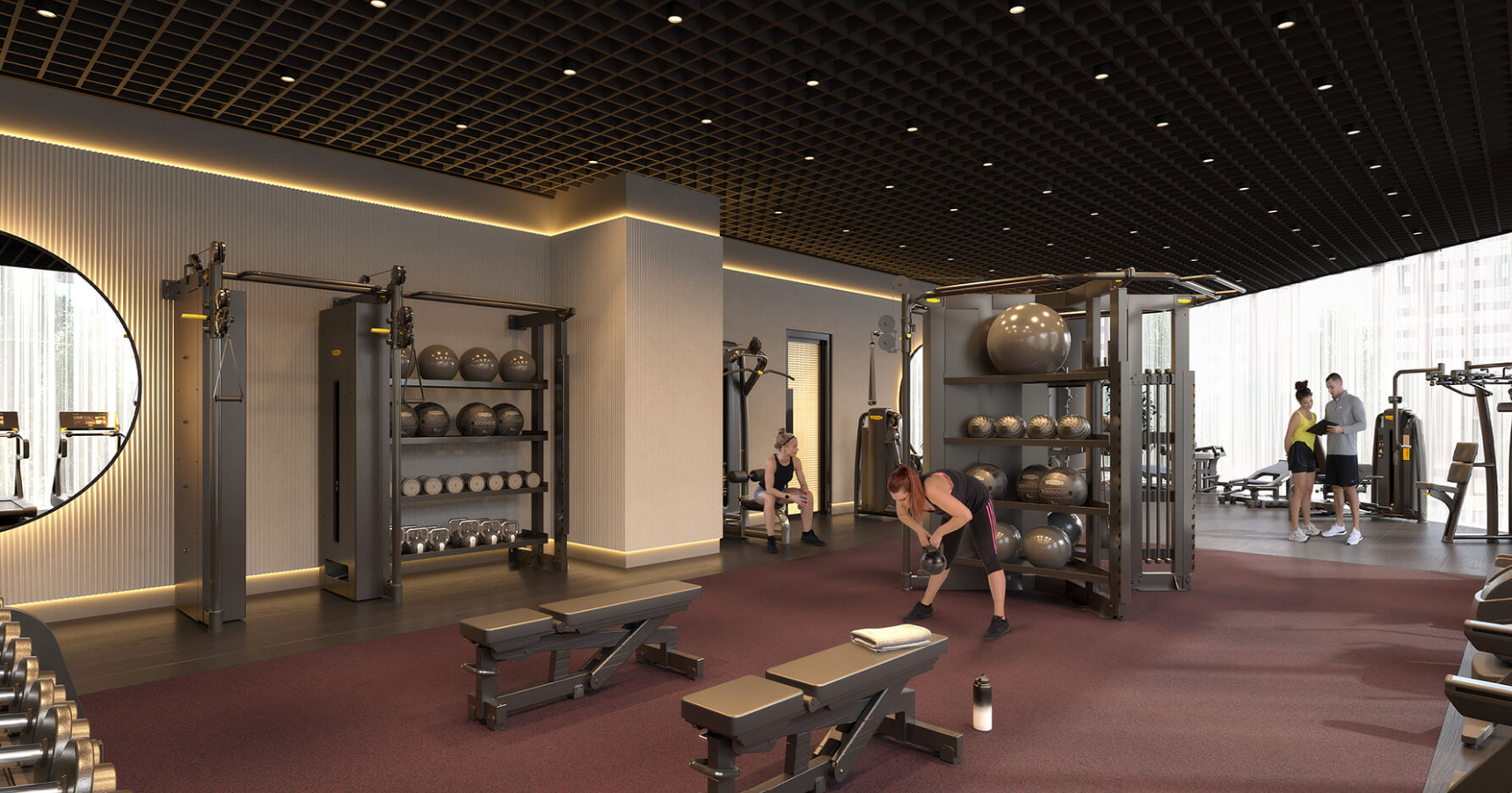 Modern gym with people working out; weights, benches, and fitness balls.