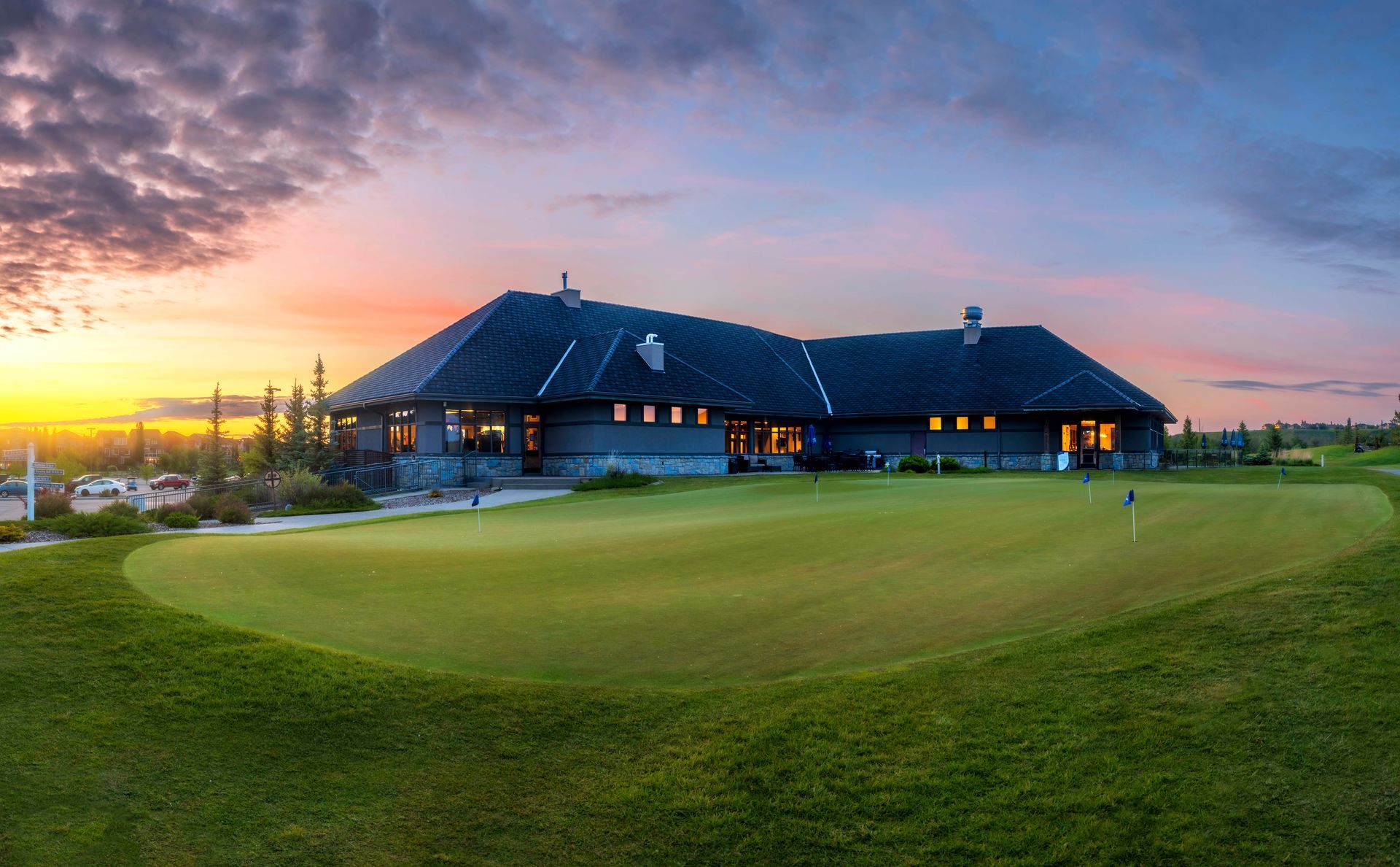 Golf cart on green grass with a double rainbow arching overhead.