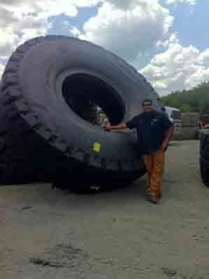 Man Beside Giant Tire — Tuscaloosa, AL — Hank's Auto Glass, Inc.