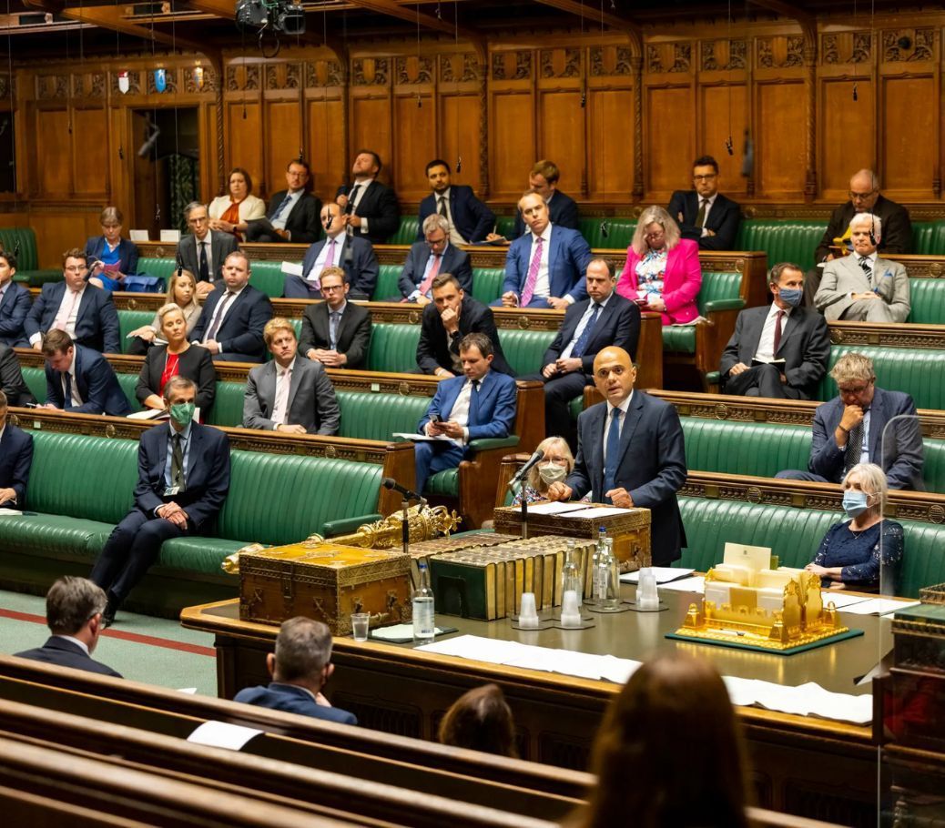 A large group of people are sitting in a parliament chamber.