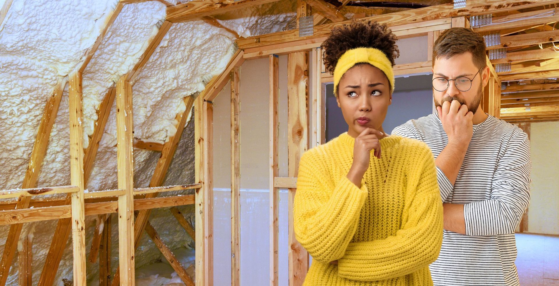 A man and a woman are standing in front of a house under construction.