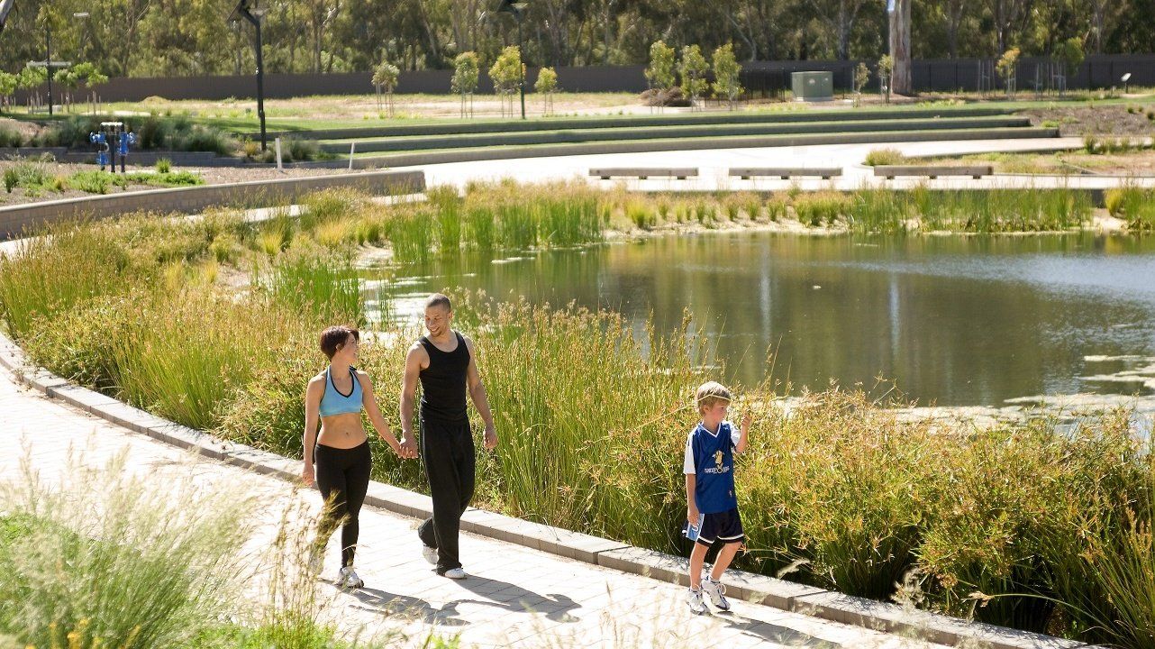 A group of people are walking along a path next to a lake.