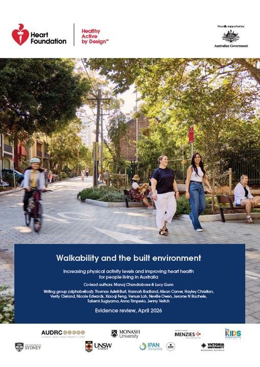 People walking and riding a bike in a shared zone with public seating and greenery