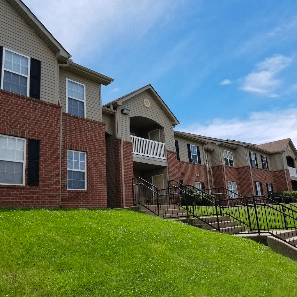 A photo of a long, multi-story apartment building with stairs leading up to it