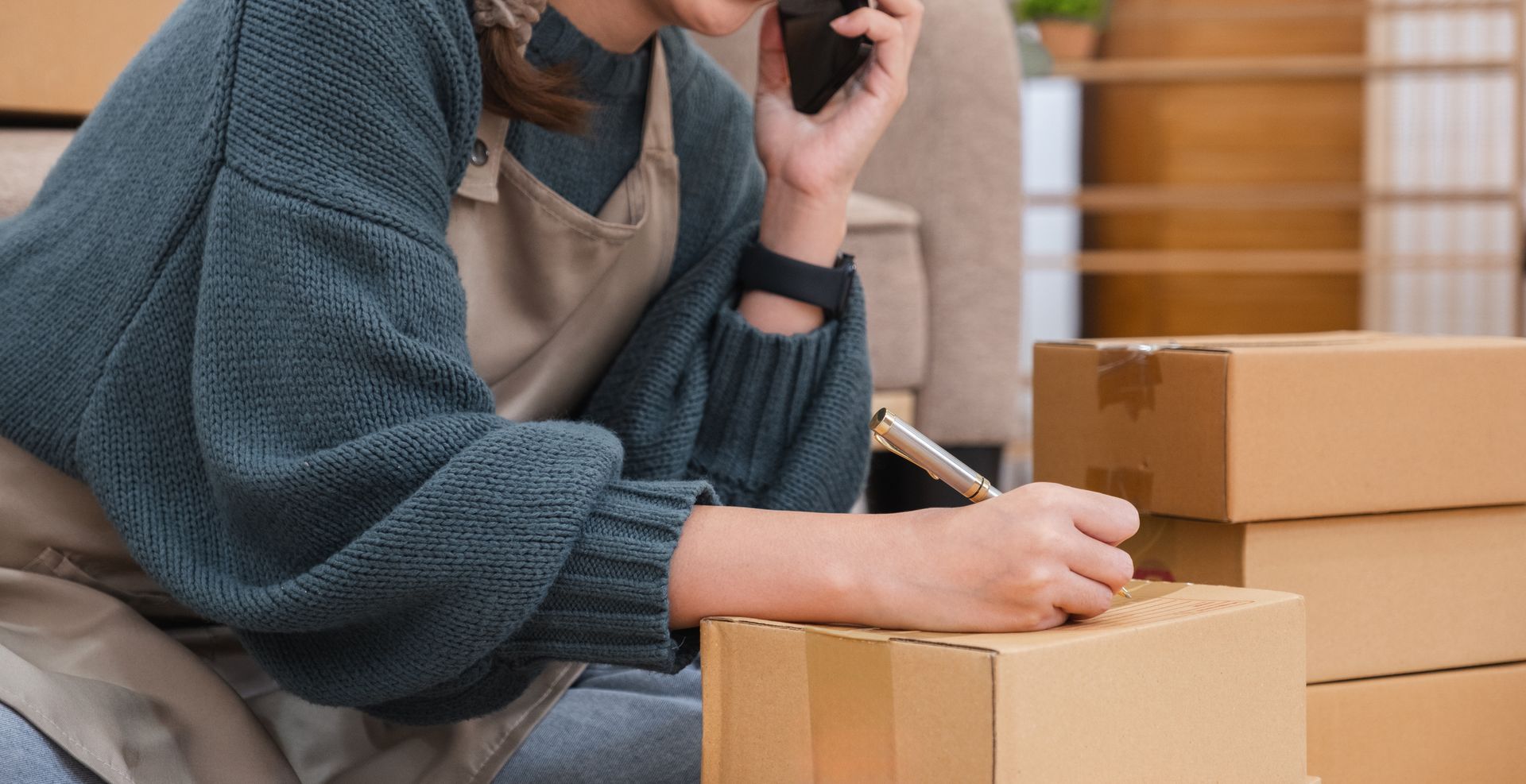 A store owner labeling boxes for a retail move across town.