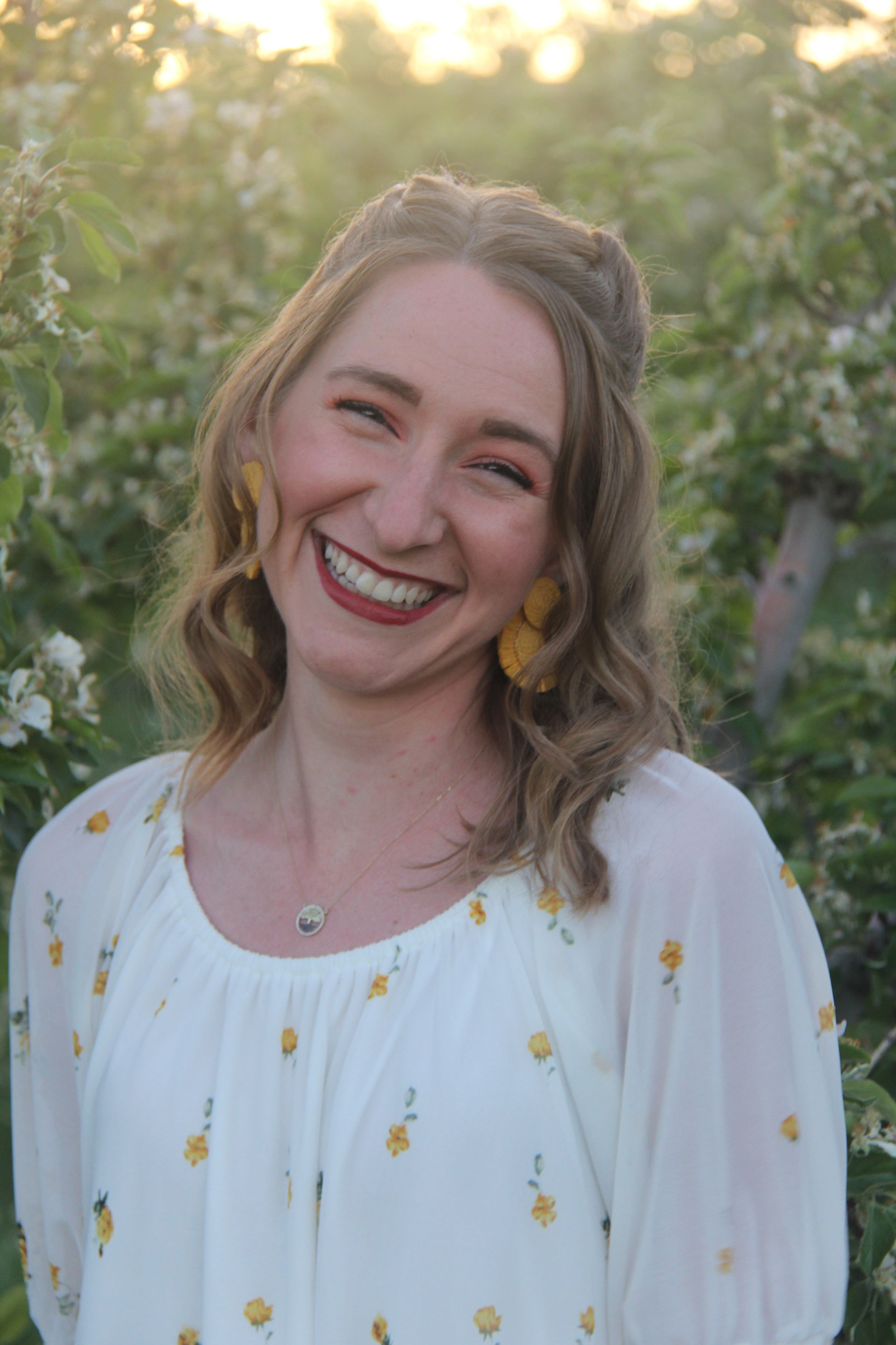 Family of five sitting on a porch swing. Smiling. Natural setting.