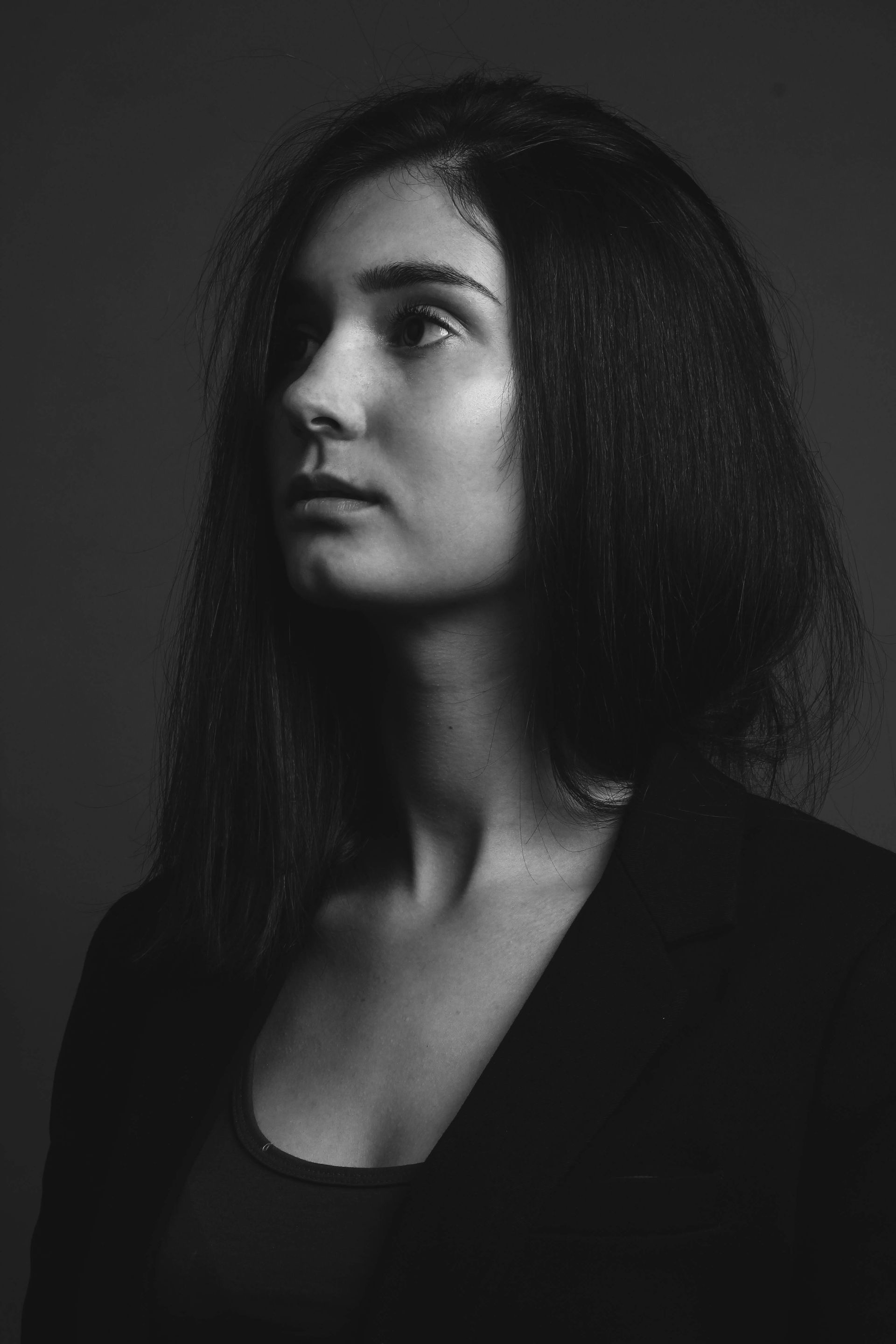A black and white photo of a woman with long hair looking up.