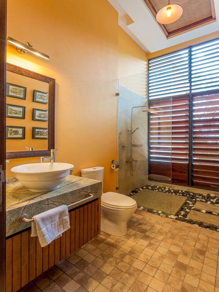 A bathroom with a toilet a sink and a mirror