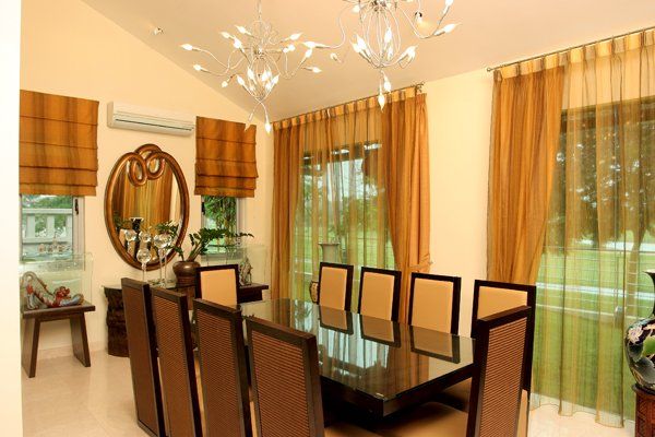 A dining room with a table and chairs and a mirror