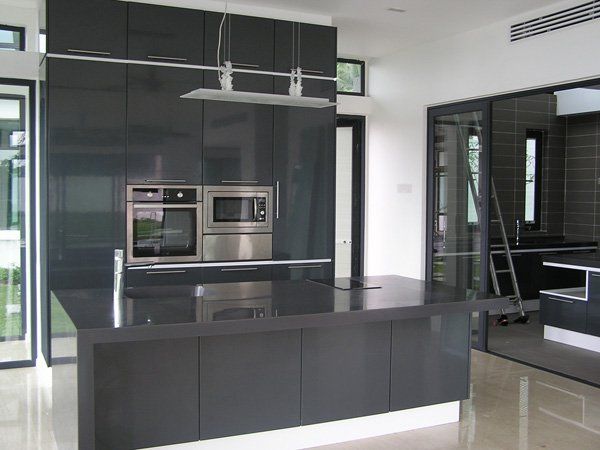 A kitchen with black cabinets and stainless steel appliances