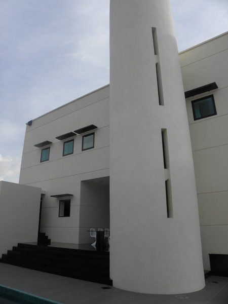 A white building with a very tall tower on the side