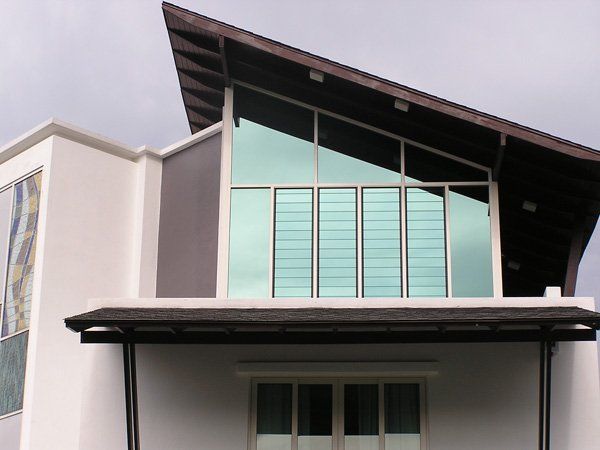 A white building with a brown roof and a lot of windows