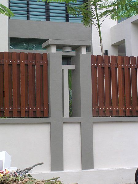 A white wall with a wooden fence in front of it