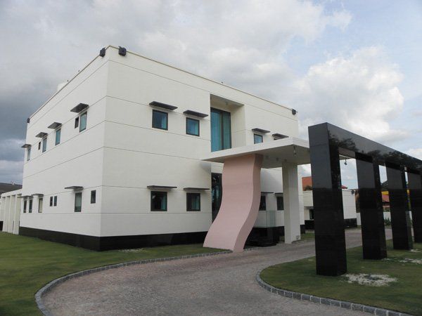 A white building with a pink pillar in front of it