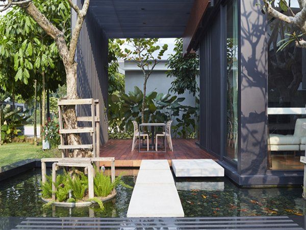 A patio with a table and chairs next to a pond