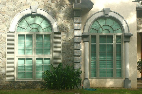 Two arched windows on the side of a building- past project by De Vetron