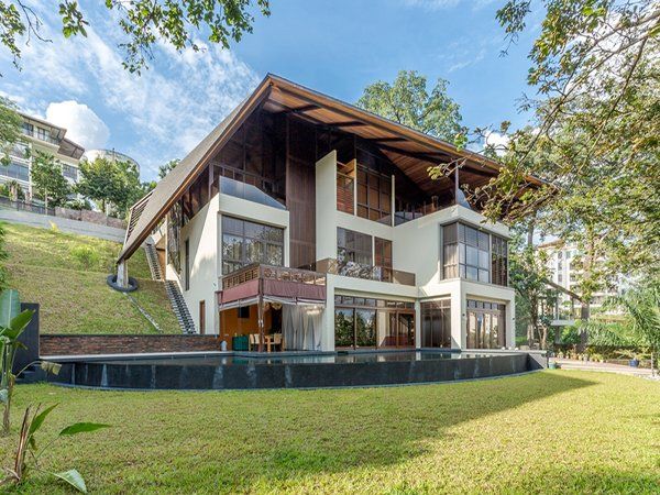 A large house with a swimming pool is sitting on top of a hill.