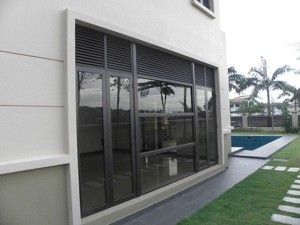 A large window on the side of a building with a pool in the background