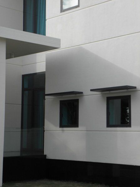 A white building with black windows and a blue curtain