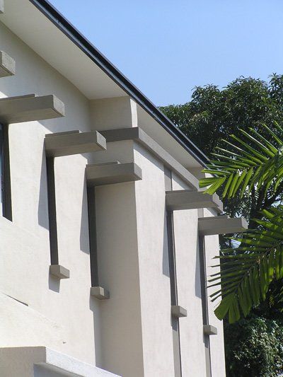 A white building with a palm tree in the background