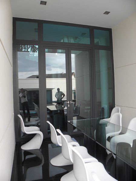 A room with white chairs and a glass table