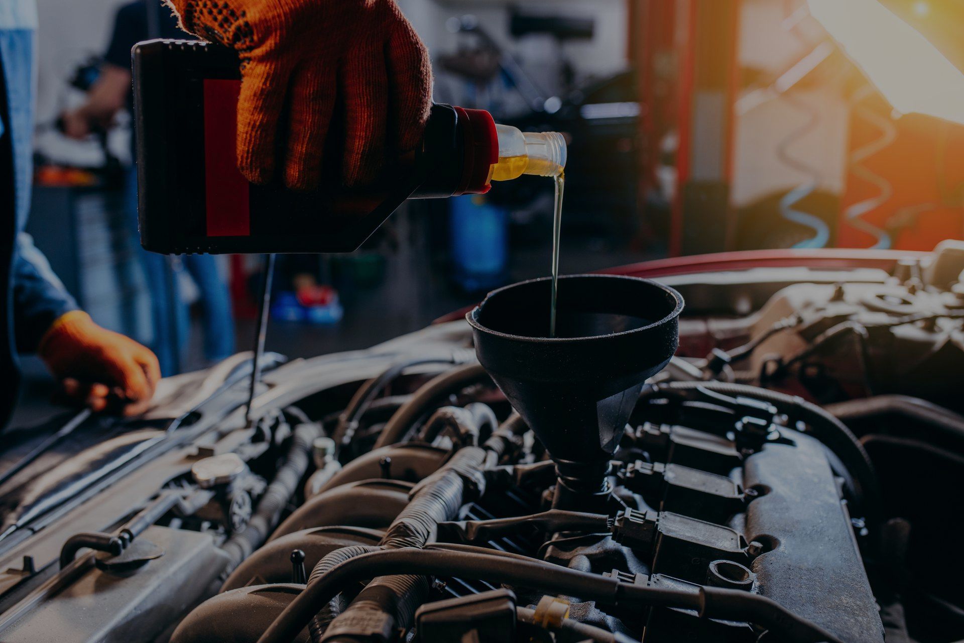 A person is pouring oil into a car engine.
