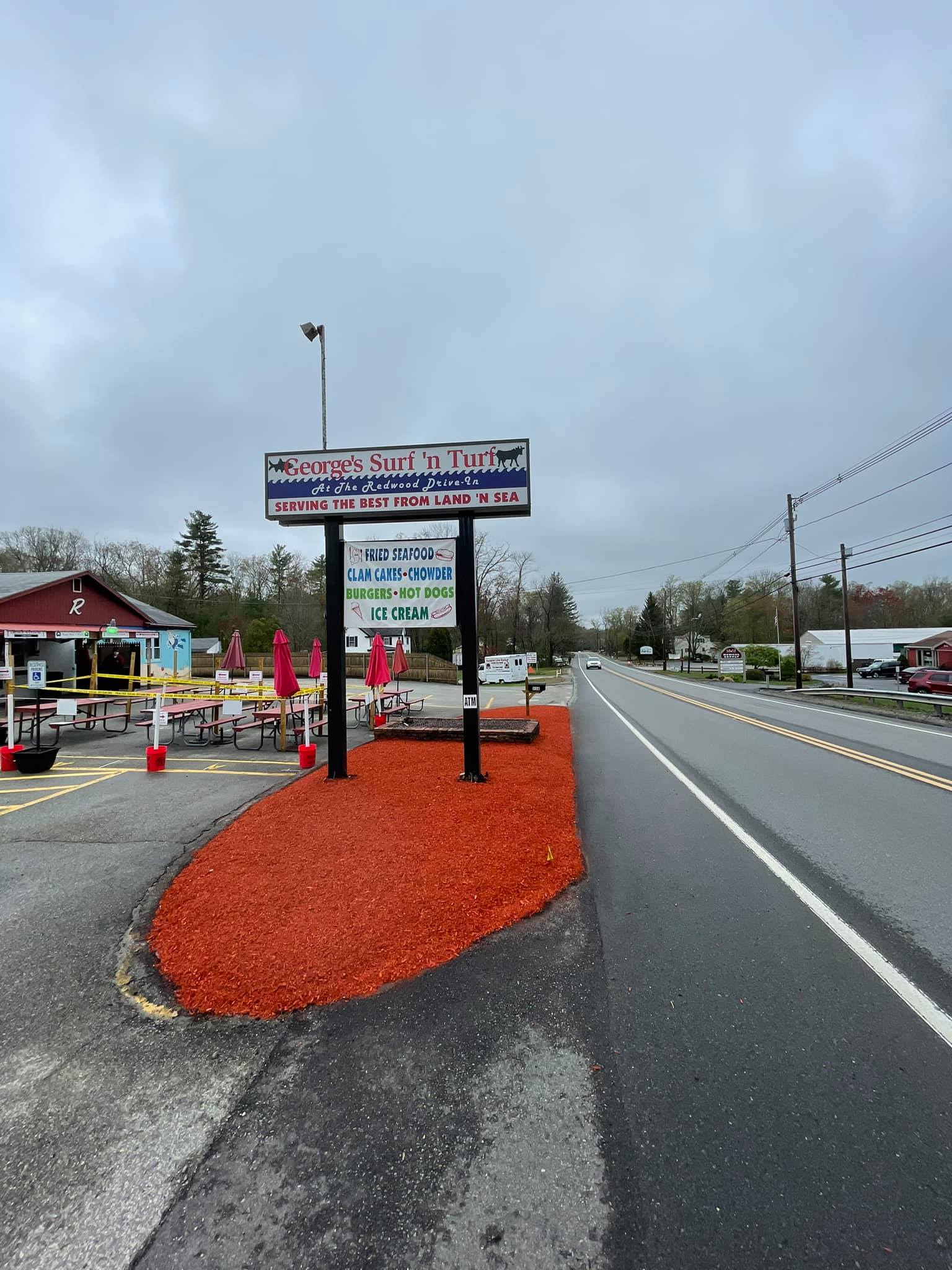 A large sign on the side of a road next to a road.