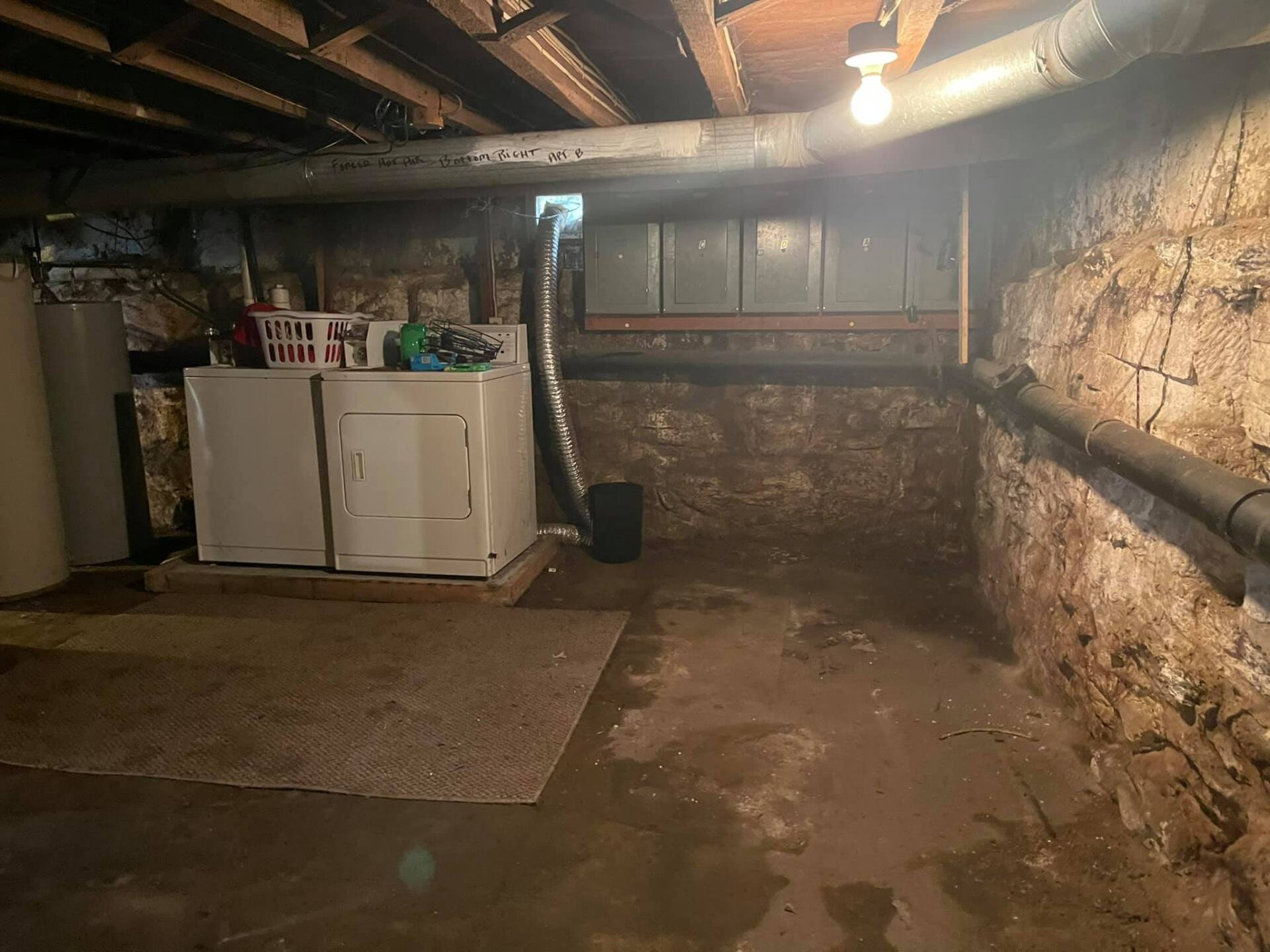 A laundry room in a basement with a washer and dryer.