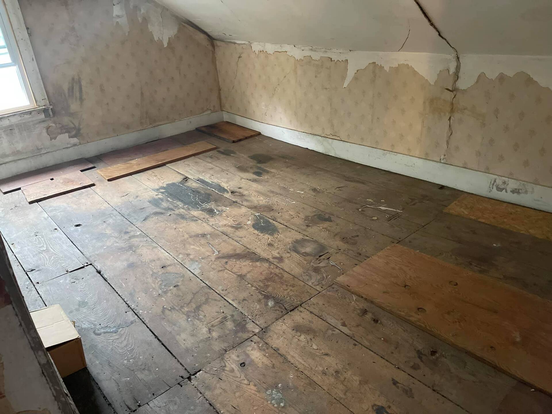 A room with a wooden floor and a window.