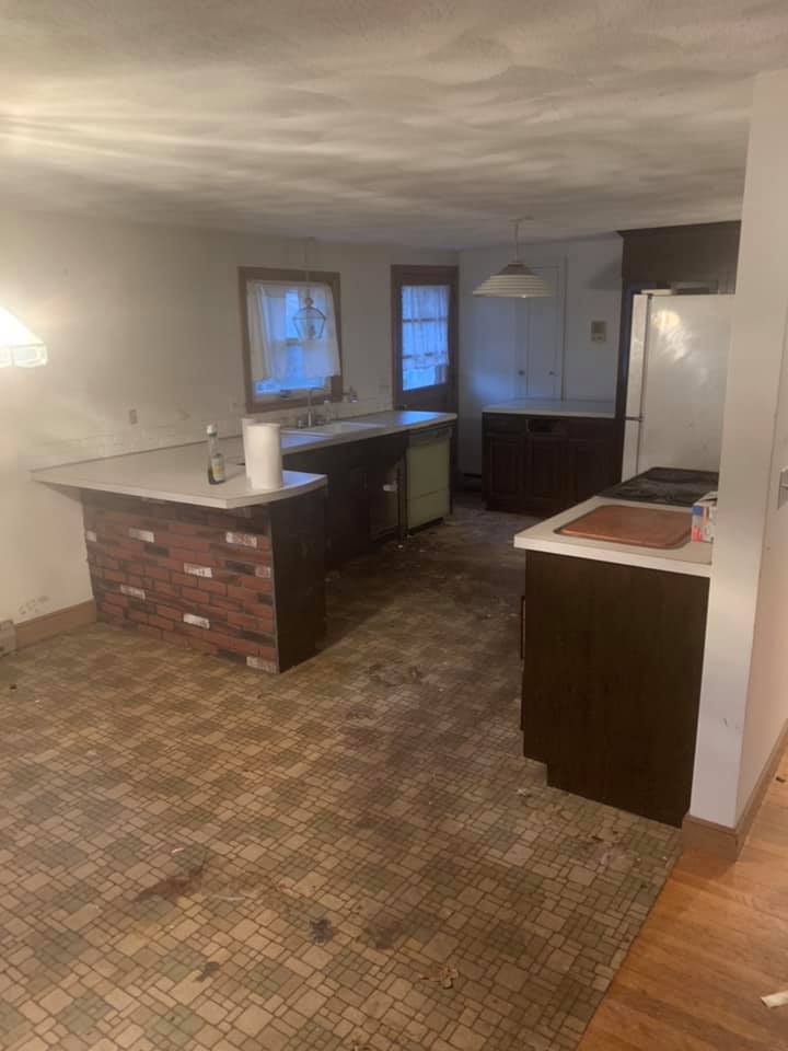 A kitchen with a brick island in the middle of the room.