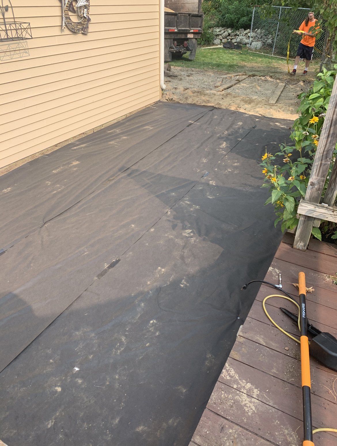 A lawn mower is sitting on a wooden deck in front of a house.