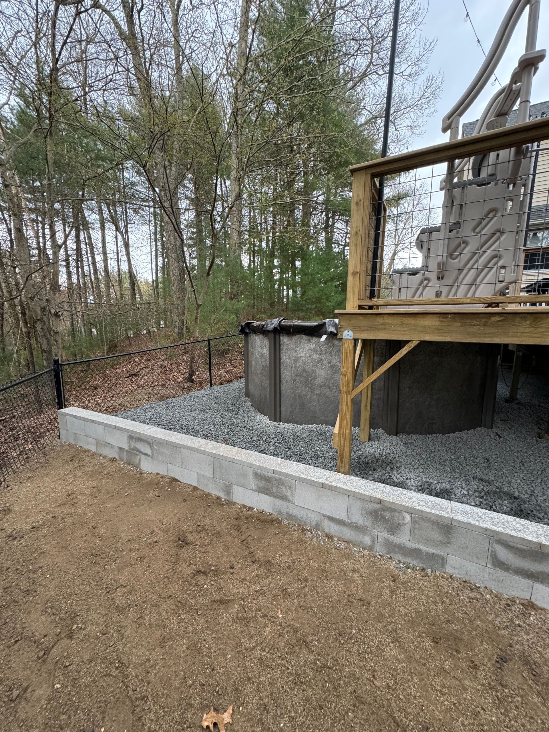 A wooden deck with a swimming pool underneath it.