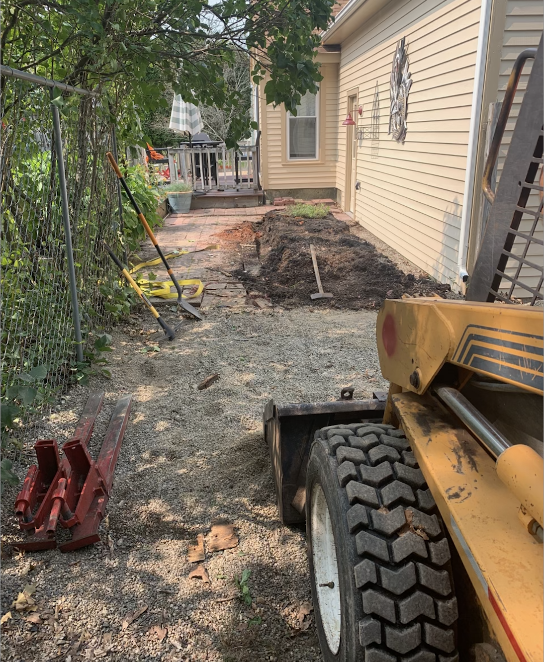 A yellow tractor is parked in front of a house.