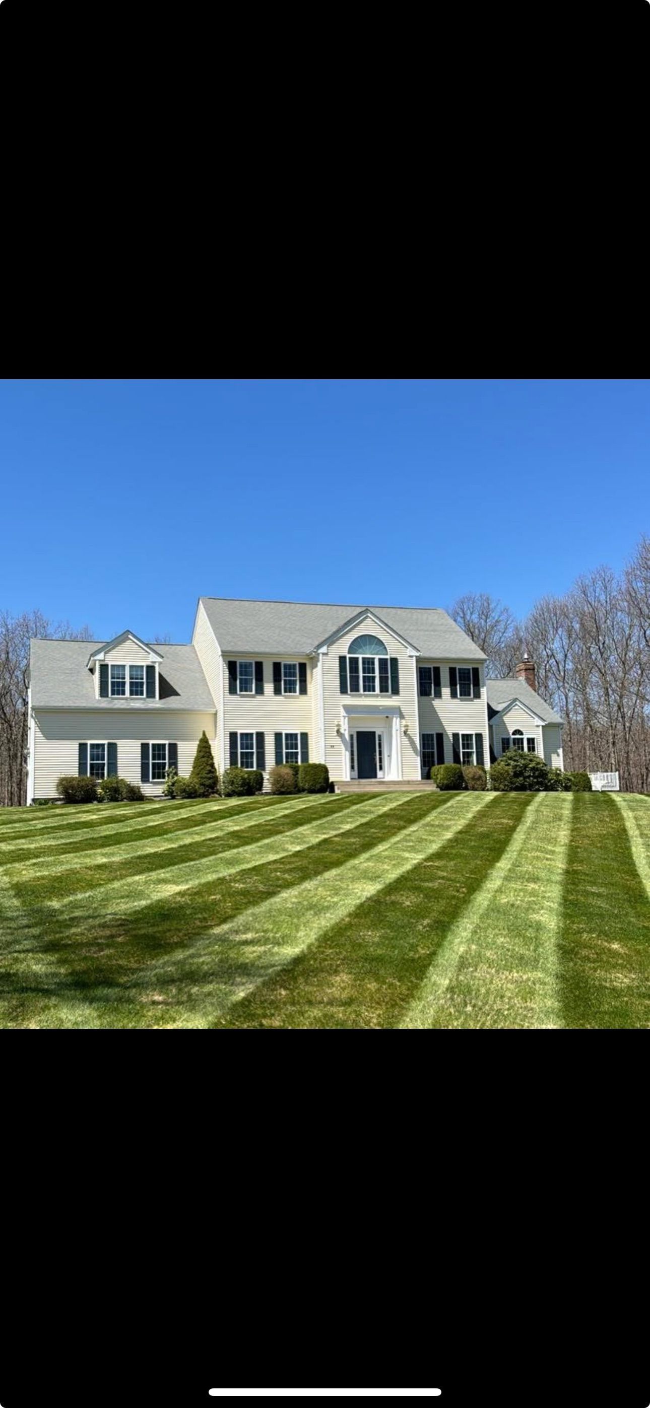 A large white house with a lush green lawn in front of it.