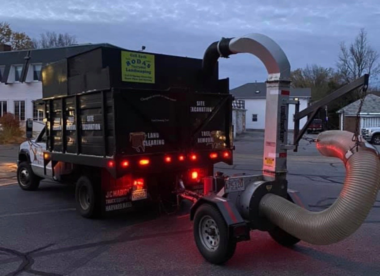 A truck with a vacuum attached to the back of it