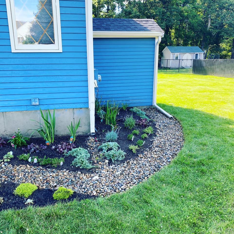A blue house with a garden in front of it.