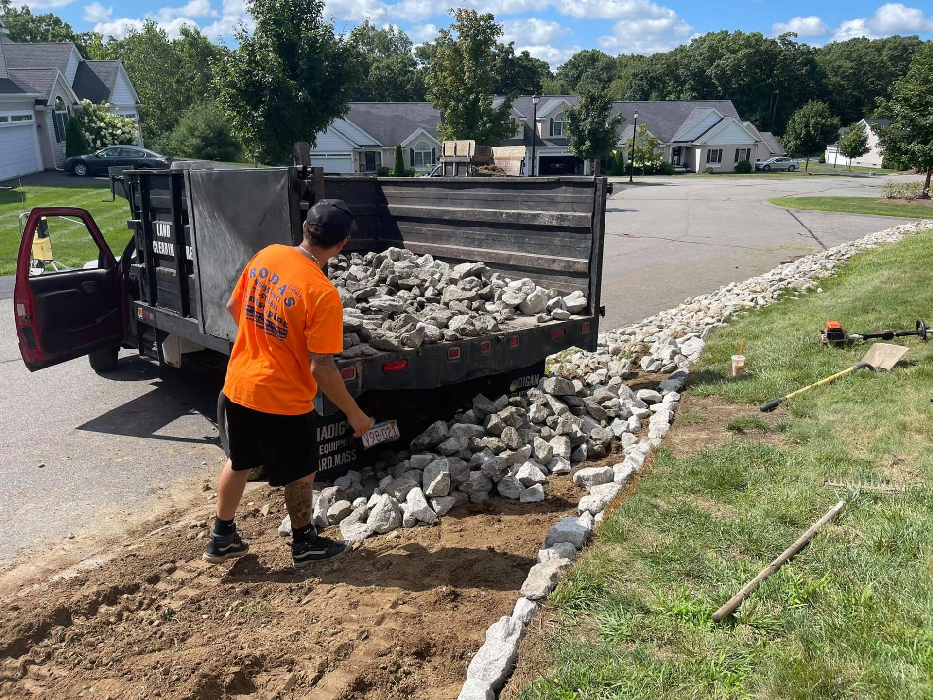 A man is loading rocks into a dump truck.
