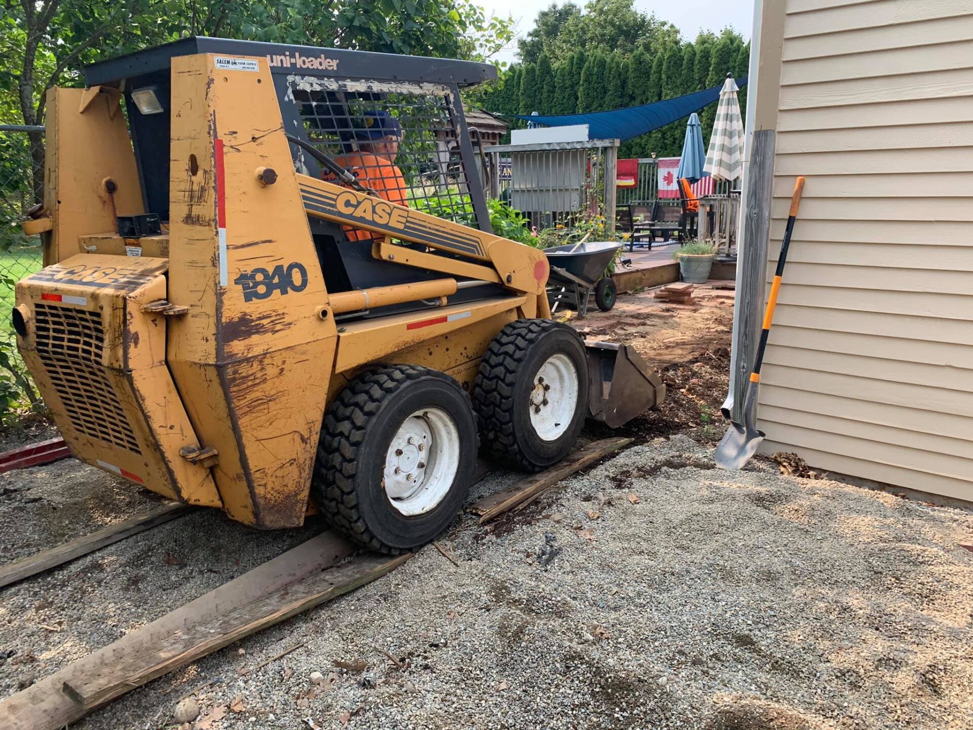 A yellow tractor is parked in front of a house.