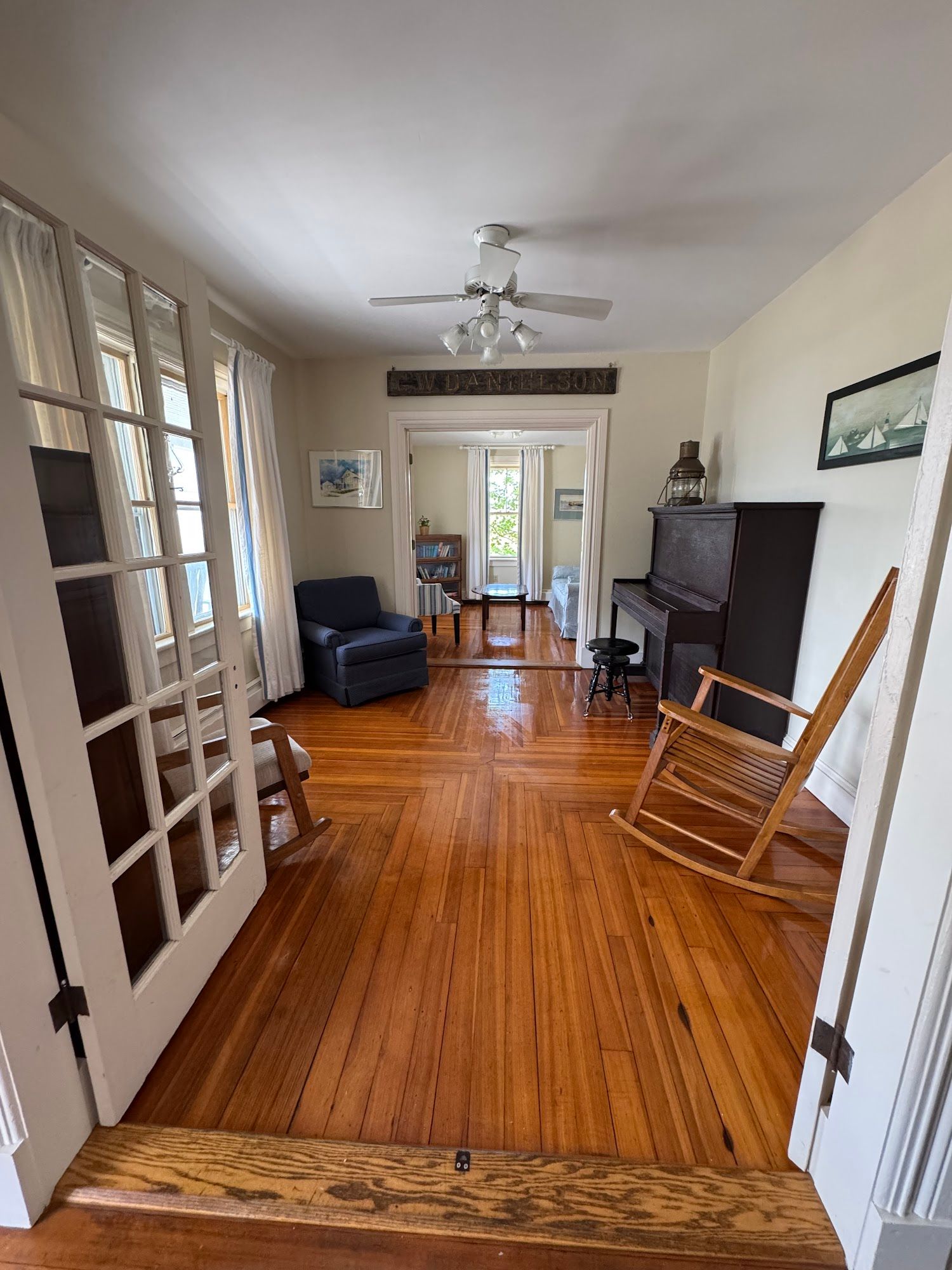 A living room with hardwood floors and a rocking chair.