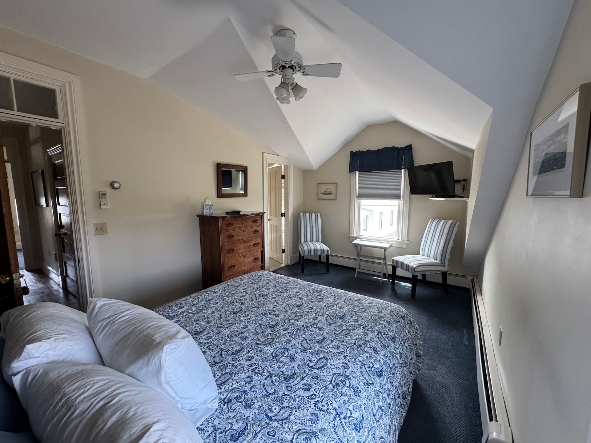 A bedroom with a large bed and a ceiling fan