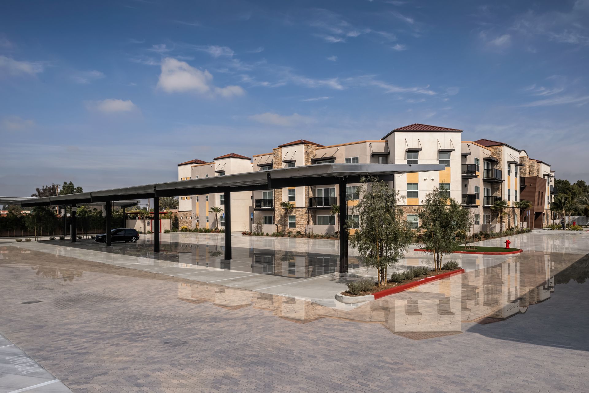 A large apartment building with a parking lot in front of it.