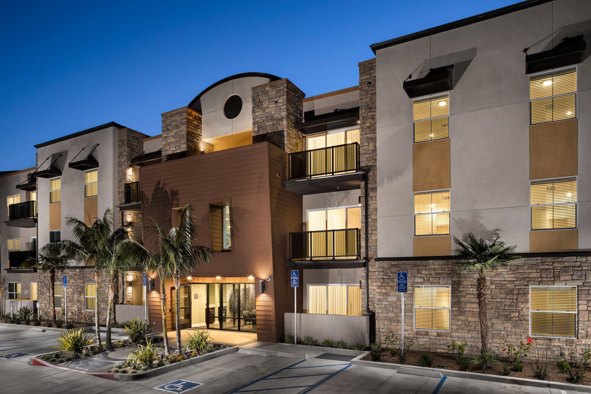 A large apartment building with a parking lot in front of it