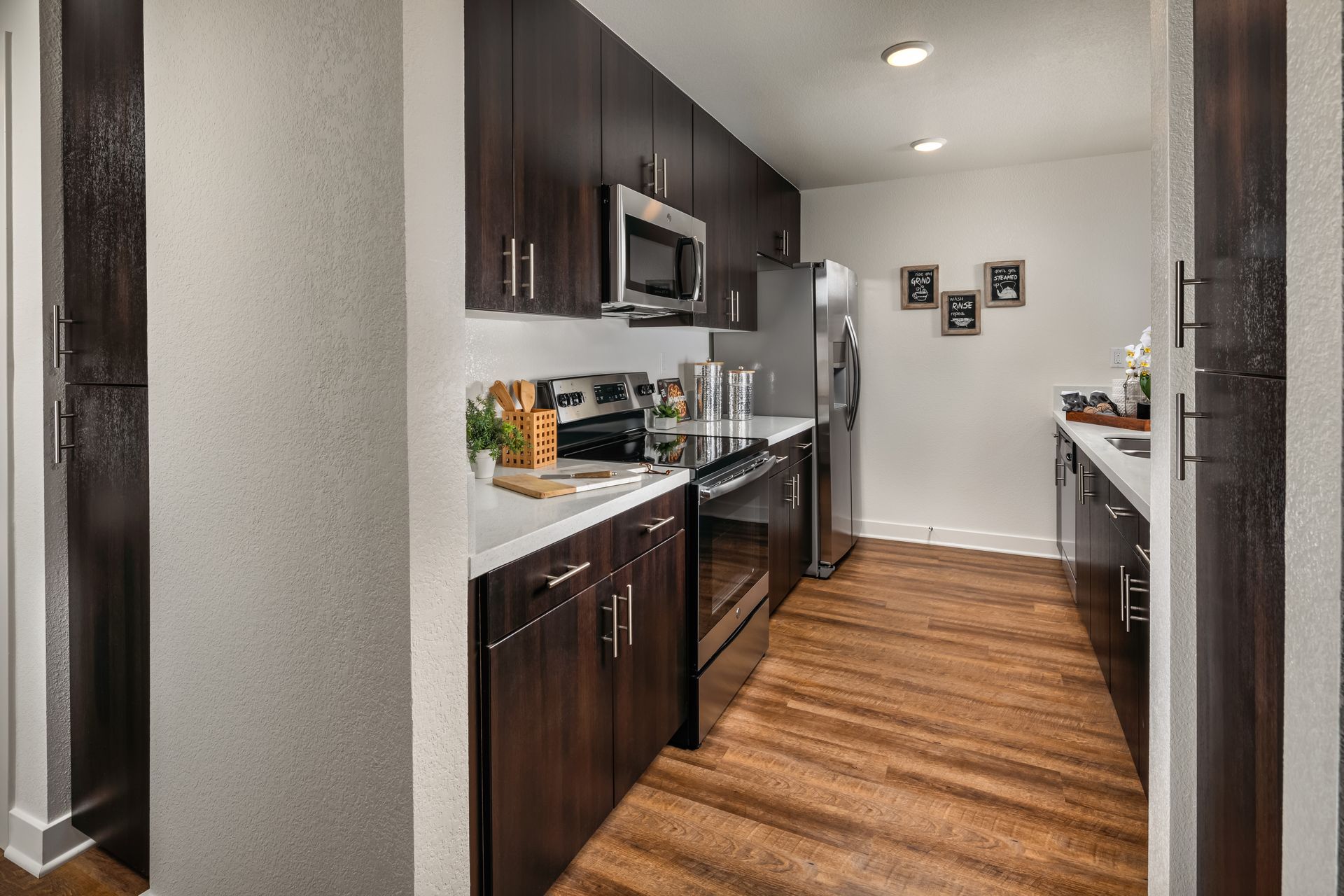 A kitchen with stainless steel appliances and wooden floors.